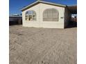 Tan mobile home with covered porch and large windows, side yard view at 6214 Mount Rainier Ave, Las Vegas, NV 89156