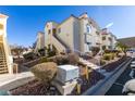 Attractive exterior of a multi-story condo building with well-maintained landscaping, stairs, and common areas at 698 S Racetrack Rd # 711, Henderson, NV 89015