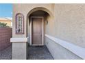 Front entry with arched entryway and decorative wall art at 772 Crimson Peak Pl, Henderson, NV 89011