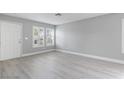 Living room with gray walls, light gray wood-look flooring, and white shutters at 8016 Roundup Ridge St, Las Vegas, NV 89131