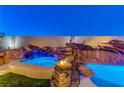 Stunning backyard oasis with a waterfall, spa, and fire pit at 8104 Via Del Cerro Ct, Las Vegas, NV 89117