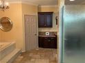 Main bathroom with a large shower, a soaking tub, and dark wood cabinets at 2438 Ping Drive, Henderson, NV 89074