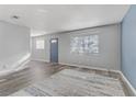 Bright living room showcasing wood flooring, a blue entry door, and a large window at 3801 Daisy St # 42, Las Vegas, NV 89119