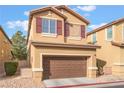 Attached garage with brown door and neutral exterior at 5738 Wind Tower St, North Las Vegas, NV 89031