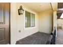 Covered patio with brick flooring, a door and window with blinds at 675 Omaggio Pl, Henderson, NV 89011