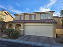 Two-story house with a two-car garage and desert landscaping at 11998 Camden Brook St, Las Vegas, NV 89183