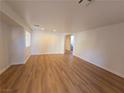 Spacious living room with light wood laminate flooring at 11998 Camden Brook St, Las Vegas, NV 89183