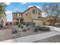 Two-story house with beige exterior, landscaped front yard, and attached garage at 165 Arrow Point Ln, Henderson, NV 89011