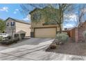 Tan two story house with attached garage and desert landscaping at 165 Arrow Point Ln, Henderson, NV 89011