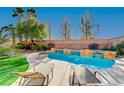 Relaxing kidney-shaped pool with tanning ledges and lounge chairs at 3733 Via Di Girolamo Ave, Henderson, NV 89052