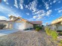 Single-story home with a two-car garage and desert landscaping at 7732 Beverly Hills Dr, Las Vegas, NV 89147