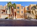 Three story tan stucco home with attached garage at 9378 Hilgard Ave, Las Vegas, NV 89178