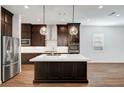 Bright kitchen with a large island, dark wood cabinets, stainless steel appliances, and white countertops at 395 Nine Mile Creek Dr, Las Vegas, NV 89138