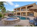 Luxurious backyard with a large pool, hot tub, covered patio, and a desert landscape at 5805 Cabo San Lucas Ave, Las Vegas, NV 89131