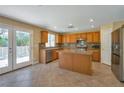 Well-lit kitchen featuring stainless steel appliances, wooden cabinetry, and a central island at 5915 Poplar Tree St, Las Vegas, NV 89148