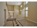Bright and spacious living room with high ceilings, tile flooring and staircase access to second floor at 5915 Poplar Tree St, Las Vegas, NV 89148