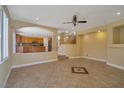 Open-concept living space with tile flooring, ceiling fan, and seamless access to the kitchen area at 5915 Poplar Tree St, Las Vegas, NV 89148
