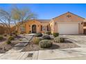 Tan colored house with a three-car garage and desert landscaping at 993 Starlight Terrace Way, Mesquite, NV 89034