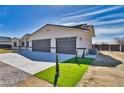 Spacious three-car garage featuring a concrete driveway and minimalist landscaping at 1131 Blackhorn St, Pahrump, NV 89048