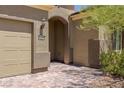 Front entrance with brick pavers, arched entryway, and a tan stucco exterior at 1359 Skylight Way, Mesquite, NV 89034