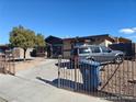 Tan house with dark brown trim, security bars on windows, and a vehicle parked in the driveway at 3660 Timberlake Dr, Las Vegas, NV 89115