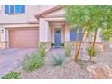 Landscaped front yard with gray front door and porch at 4025 Redwood Glen Ct, Las Vegas, NV 89141