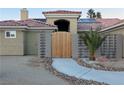 Landscaped front yard with a wooden gate, walkway, and decorative rock at 8032 Deep Stone Ave, Las Vegas, NV 89149