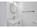 A well-lit half bathroom with a modern sink, mirror, and towel rack at 9247 Tulip Trestle Ave, Las Vegas, NV 89148