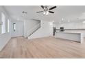 Bright and airy open-concept living space with hardwood floors, a staircase, and an adjacent kitchen at 9247 Tulip Trestle Ave, Las Vegas, NV 89148