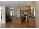 Kitchen features island, stainless steel appliances, and wood cabinets at 1434 Summer Glow Ave, Henderson, NV 89012