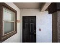 Entryway featuring a black door with gold hardware, contrasted by the textured wall and a window to the side at 45 Maleena Mesa St # 223, Henderson, NV 89074