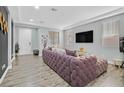 Living room with plush purple sectional sofa and wood-look floors at 6554 Macdoogle St, Las Vegas, NV 89166