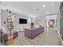 Living room with plush purple sectional sofa and wood-look floors at 6554 Macdoogle St, Las Vegas, NV 89166