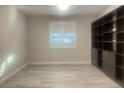 Room with hardwood floors, a window with shutters, and large built-in shelves at 2110 Millergrove Ave, North Las Vegas, NV 89086