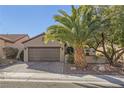 Single-story house with brown garage door and palm trees at 2401 Weaverville Dr, Henderson, NV 89044