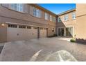 Spacious, multi-car garage with a large, patterned concrete driveway and neutral-colored facade at 2717 Mona Lisa St, Henderson, NV 89044