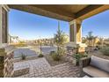 Cozy patio with brick paving, seating area, and view of the neighborhood at 3615 Bitonto Ln, Henderson, NV 89044