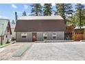 Gray metal exterior home with brown roof, paved driveway, and landscaping at 4765 Silver Tip Trl, Mount Charleston, NV 89124