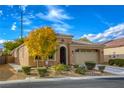 Beautiful tan home with lush landscaping and a two car garage at 5741 Pleasant Palms St, North Las Vegas, NV 89081