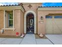 Ornate iron gate entry to a light tan home with a two-car garage at 5741 Pleasant Palms St, North Las Vegas, NV 89081