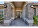 Inviting entryway with a wrought iron door and stone pillars at 5977 Ancient Peaks Ave, Las Vegas, NV 89141