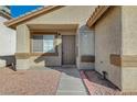 House entrance with brown door, walkway, and landscaping at 6560 Bush Clover Ln, Las Vegas, NV 89156