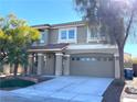 Two-story house with taupe exterior, attached garage, and landscaping at 6607 Musette Ave, Las Vegas, NV 89139