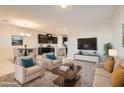Staged living room with comfortable seating, contemporary decor, and seamless connection to the kitchen and dining area at 762 Star Estates Ave, North Las Vegas, NV 89086