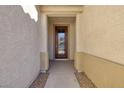 Front entry with a wood door and stone flooring at 844 Via Serenelia, Henderson, NV 89011