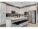 Modern kitchen featuring stainless steel appliances, an island with seating, and white cabinetry at 889 Ariel Heights Ave, Las Vegas, NV 89138