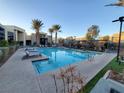 Inviting community pool with lounge chairs and palm trees at 11251 Hidden Peak Ave # 212, Las Vegas, NV 89135