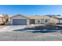 Single story home with gray garage door and landscaping at 1850 Banaba Ln, Las Vegas, NV 89156