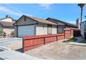 Single-story house with a red wooden fence and attached garage at 1861 Ridgefield Dr, Las Vegas, NV 89108