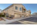 Side view of tan two-story home with three-car garage at 3309 Jamaica Princess Pl # 3, North Las Vegas, NV 89084